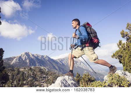 Summer hiking in the mountains with a backpack .