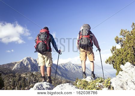 Summer hiking in the mountains with a backpack .