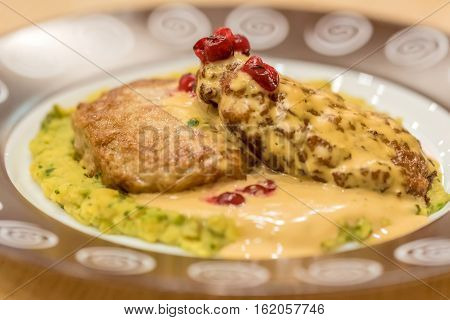 Meat patties or frikadeller in chese and mushroom sauce decorated with berries