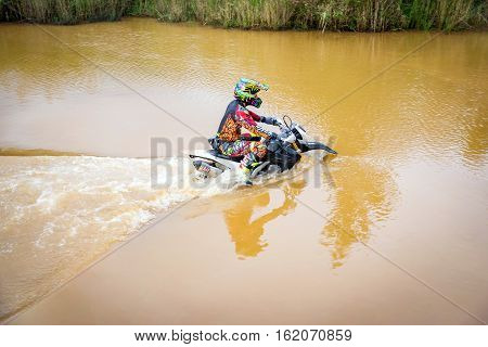 Ratchaburi,Thailand -Dec 4,2016: Motocross is trying to drive across the river to a depth of one meter in the wild.