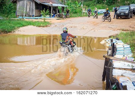 Ratchaburi,Thailand -Dec 4,2016: Motocross is trying to drive across the river to a depth of one meter in the wild.