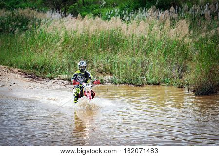 Ratchaburi,Thailand -Dec 4,2016: Motocross is trying to drive across the river to a depth of one meter in the wild.