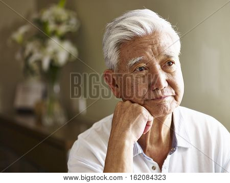 portrait of sad senior asian man hand on chin.