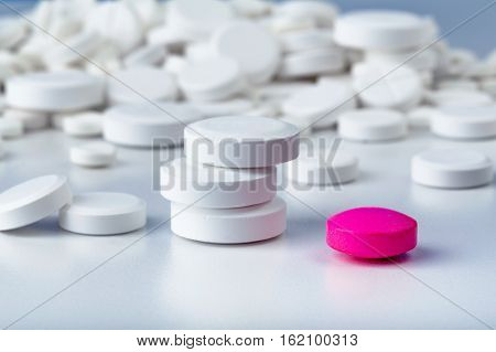 Bunch Of White Tablets. Scattered Pills. Single Pink Pill