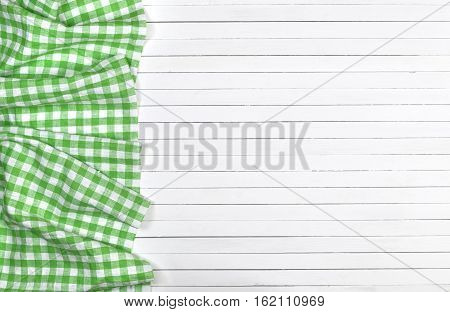 Green checkered tablecloth on a light wooden table, top view