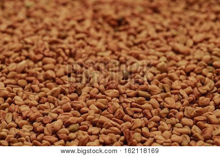 dry fenugreek seeds background on the table