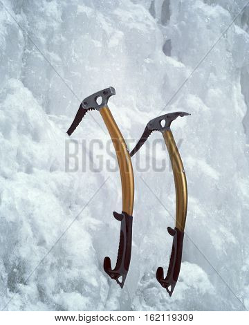 Athletic man in red coat with orange helmet and gold ice tools climbing a large blue wall of ice in the Uncomphagre Gorge