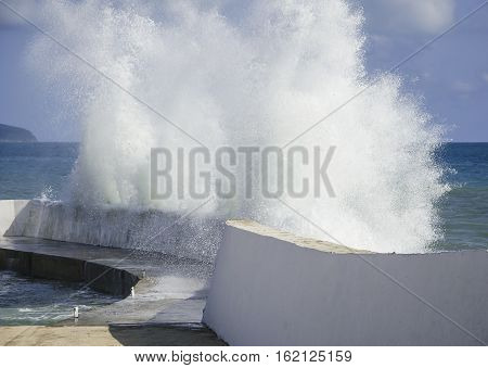 Sea strong storm waves crashing on stone pier