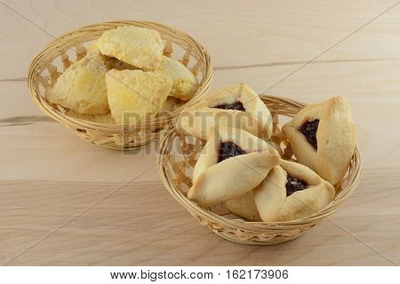 Hamantash and scones in wicker baskets on wooden table