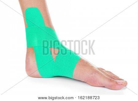 Female foot with physio tape on white background