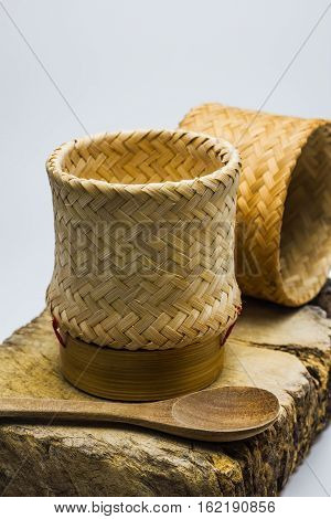 Kratip or Wicker bamboo container rice on wood block.