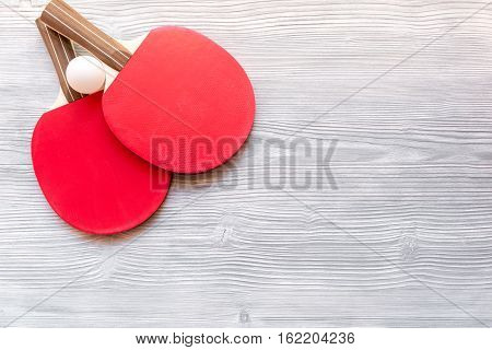 Red racket for ping pong ball on gray wooden background top view