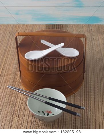 Chinese bowl with chopsticks and brown lunch box front view