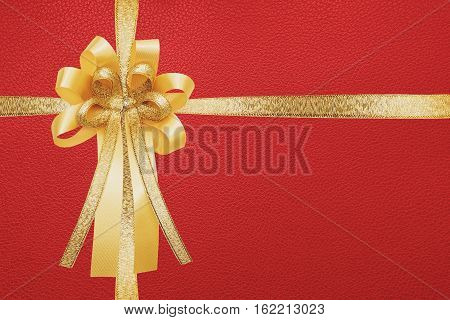 Golden ribbon and bow, wrap on red gift box background