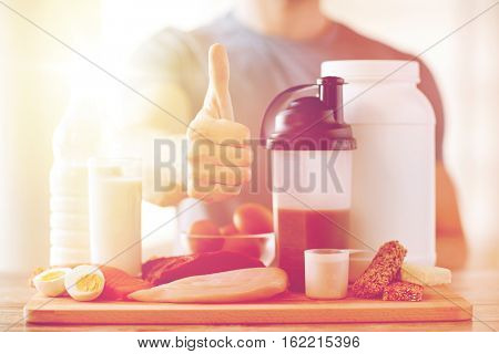 sport, fitness, healthy lifestyle, diet and people concept - close up of man with food rich in protein showing thumbs up