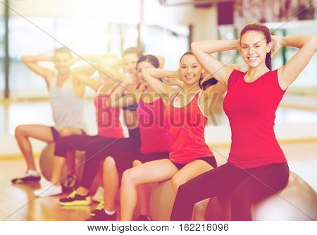 fitness, sport, training, gym and lifestyle concept - group of smiling people working out in pilates class