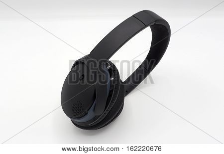 Black wireless headphone around ears and white background.