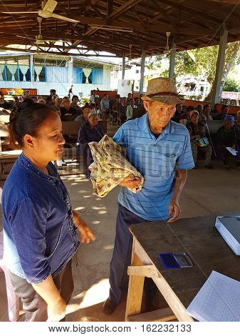 CHIANG RAI THAILAND - DECEMBER 19 : Unidentified asian officer giving old people suffering from leprosy clothing on December 19 2016 in Chiang rai Thailand.