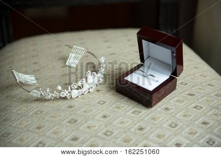 wedding rings in a brown box and a crown