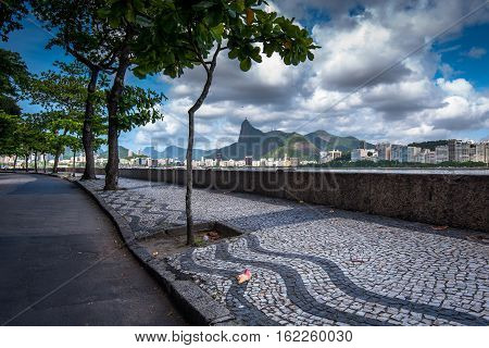 Sidewalk of Urca Neighborhood and View of Rio de Janeiro in the Horizon With Clouds in the Sky