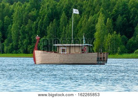 Valdaysky District, Russia - June 16, 2013: Modern wooden boat, stylized like viking ship with a dragons head for the entertainment of tourists by Andrey Kopylov, aka linkpusher