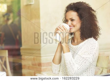 Attractive woman savouring coffee in cafe