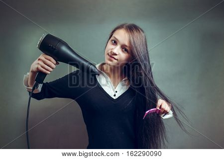 woman with long hair holding blow dryer