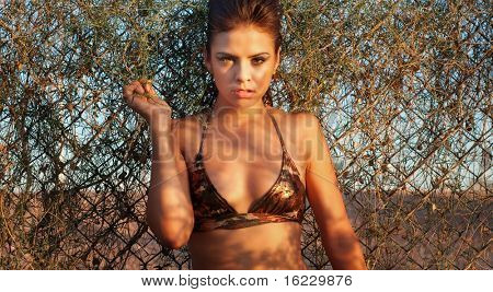 Foto de beleza moda bikini exército de mulher posando ao lado de cerca