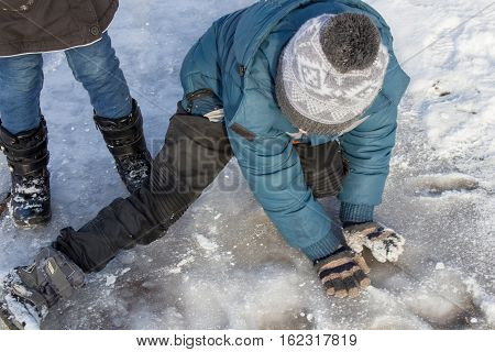 boy child falls on the ice during the winter ice