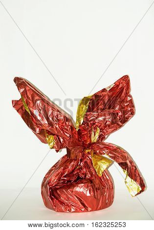 Gift in a red shiny wrapping box on a white background