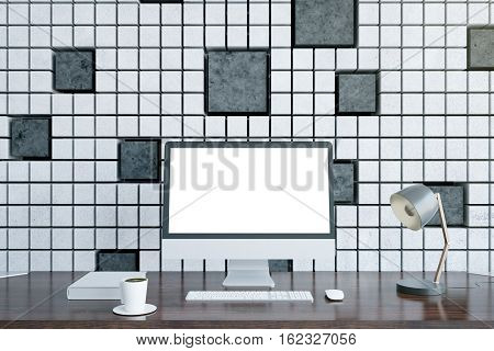 Wooden desktop with blank white computer monitor coffee cup lamp and other items on patterned tile background. Mock up 3D Rendering