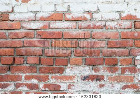 Old brick wall with peeling off paint.