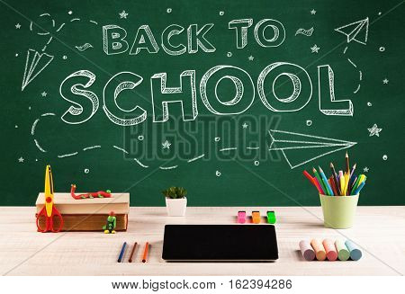 Back to school concepty with writing on blackboard and desk, apple, books, items