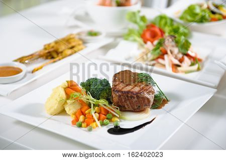 Medium rare pork steak with fresh vegetables.