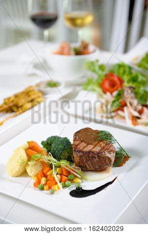 Medium rare pork steak with fresh vegetables.