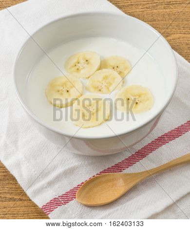 Bolw of Homemade Yoghurt Topping with Organic Banana Nutritionally Rich in Protein Calcium Riboflavin Vitamin B6 and Vitamin B12.