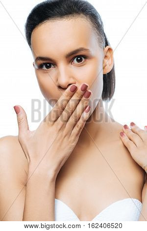 Thrilling emotions. Surprised amazed funny Negroid woman closing her mouth with hand while standing against white background and expressing amazement