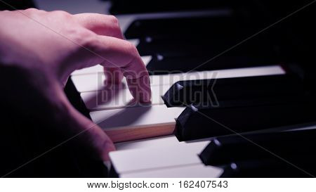 Scene of pianist hands from beside angle playing piano Photo in vintage colors style. Selective focus.