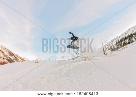 Freerider is jumping in the snow spray from the
