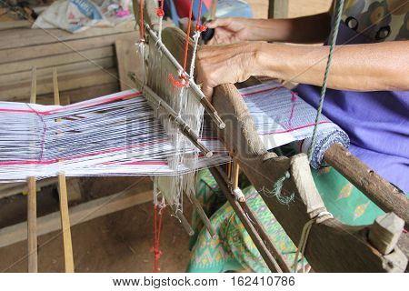 Hands Of Old Woman Who Weaves On A Loom, A Traditional Hand-weaving Loom Being Used To Make Cloth At