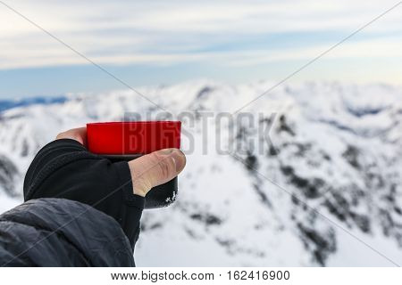 Tourist Holding A Cup Of Tea In The Winter In The Mountains.