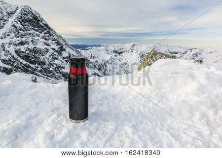 Thermos On The Snow In The Mountains.