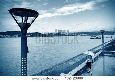 Woman holding a parasol overlooking the river Yichang Hubei China.