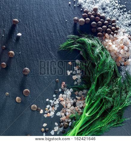 vegetables and spices on a black background, dill and pepper salt