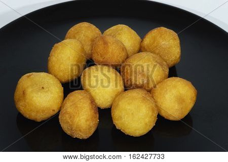 Thai snack fried potato balls on black plate.jpg