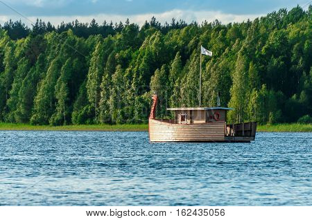 Valdaysky District, Russia - June 16, 2013: Modern wooden boat, stylized like viking ship with a dragons head for the entertainment of tourists by Andrey Kopylov, aka linkpusher