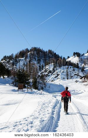 Hiker walking on the mountain pathcovered by snow
