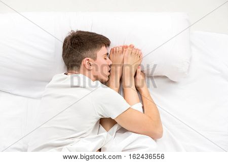 The young lovely couple lying in a white bed, love lconcept, top view