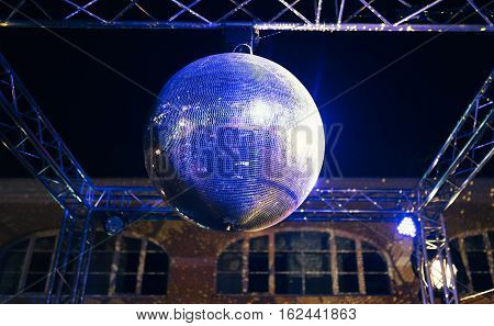 Blue lit disco ball party concept at night