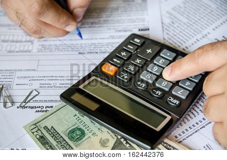 Cropped image of Businessman calculating and checking tax